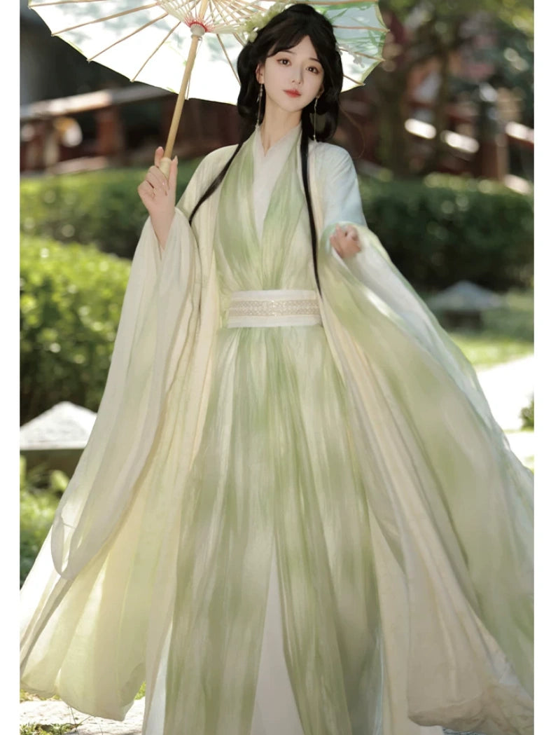 Women in Traditional Chinese Sage Green Traditional Wei-Jin Style Double-Layer Hanfu Dress Set  in a flowing green dress holding an umbrella outdoors.