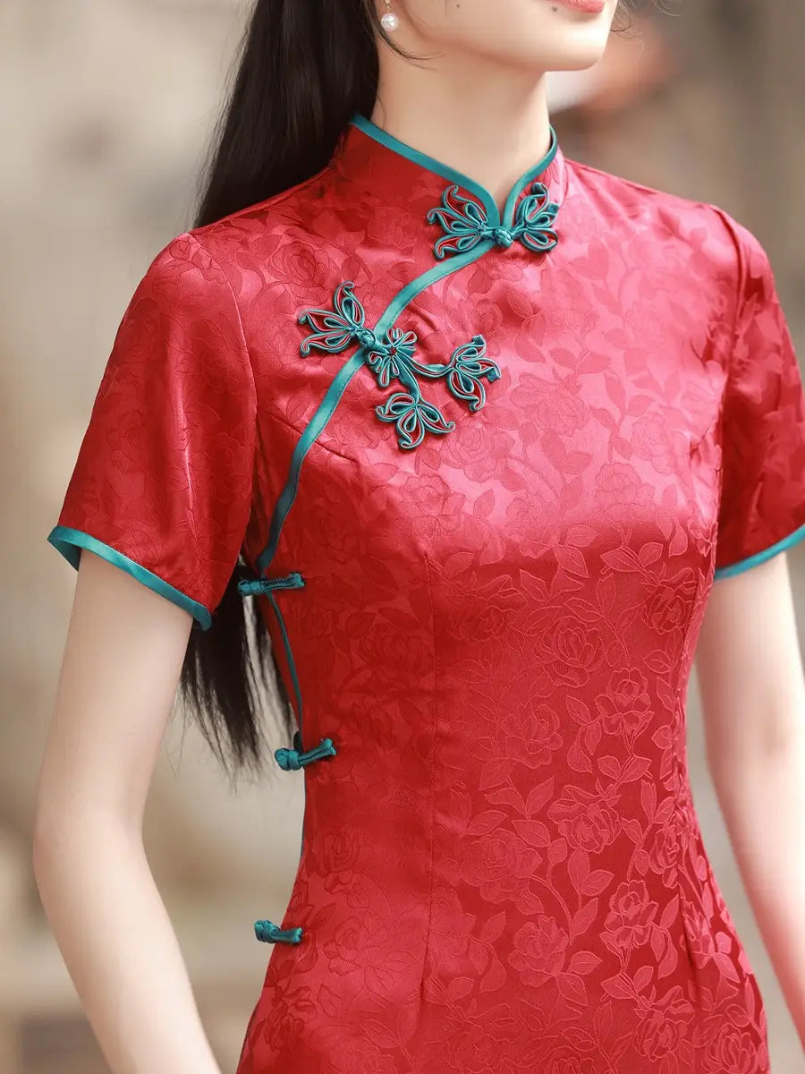 Red traditional Short Sleeves Floral Jacquard Long Qipao Dress  green accents worn by a person, blurred background