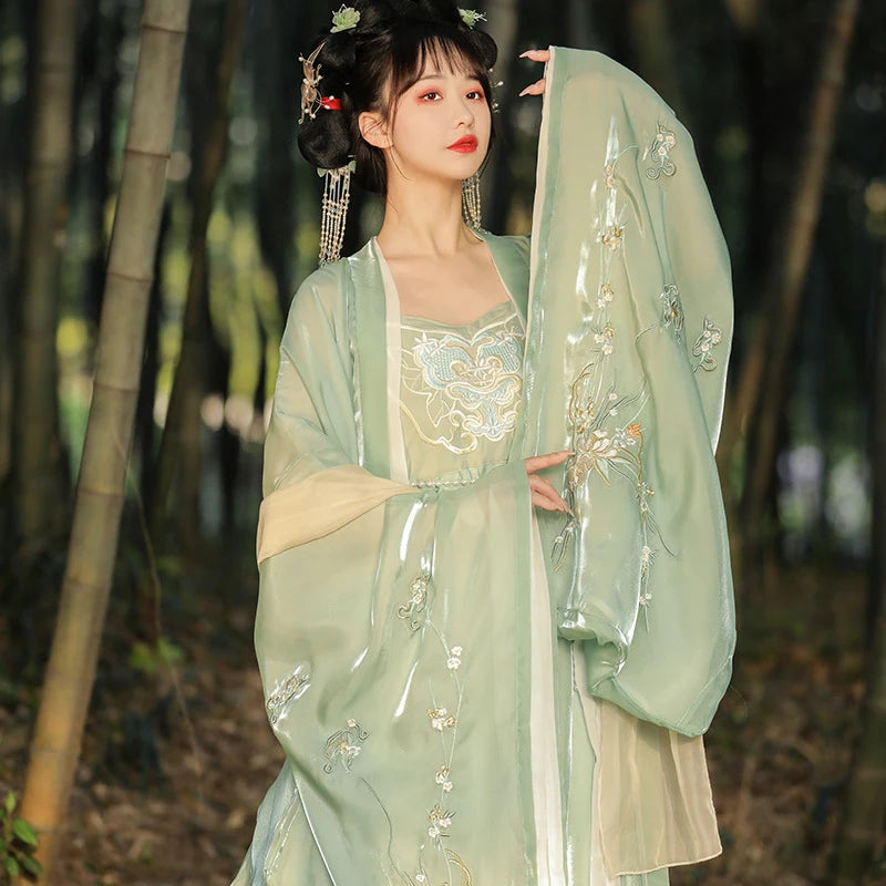 Woman in traditional light green  Tang Dynasty Hanfu Dress embroidered outfit standing in a bamboo forest