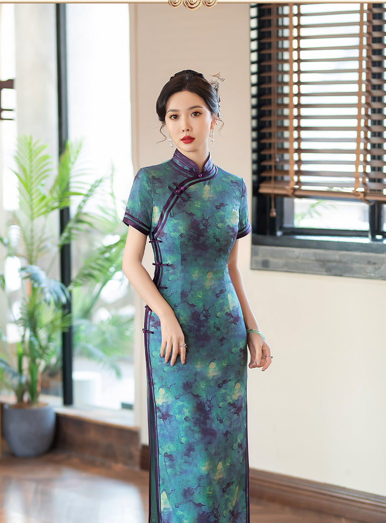 A chinese girl in  teal, blue, and purple foral cheongsam dress standing