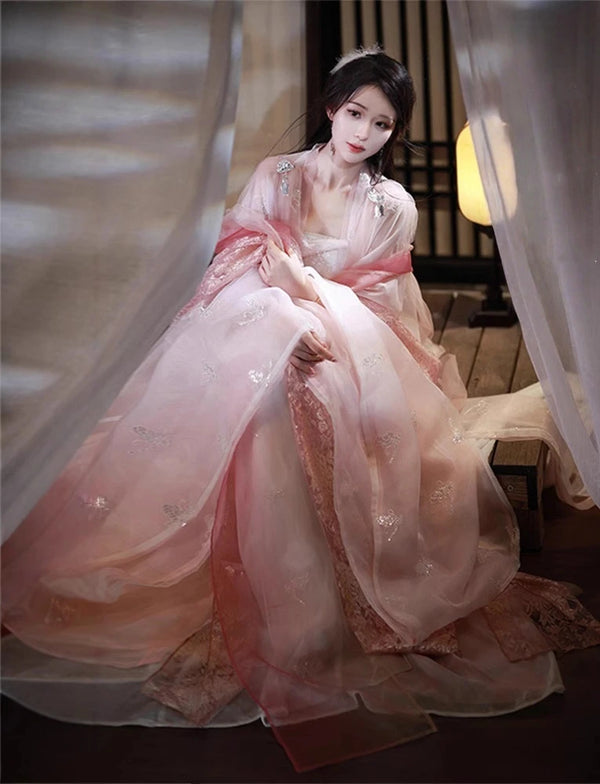 Woman in a Traditional Chinese Clothing - Pink Song Dynasty Hanfu Dress  sitting in a softly lit room.