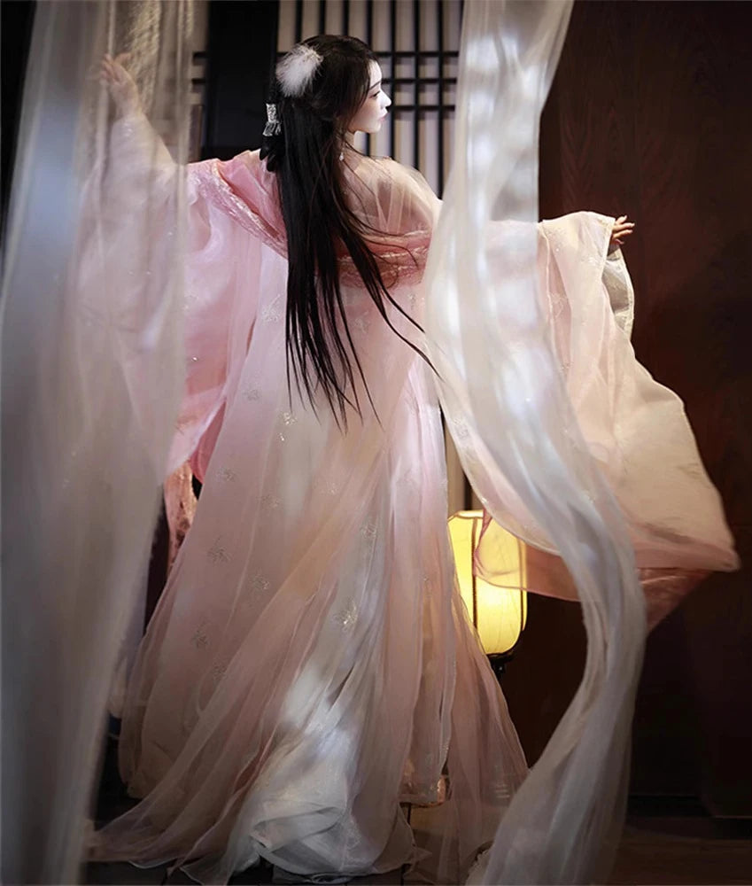 a girl in a Traditional Chinese Clothing - Pink Song Dynasty Hanfu outfit garment with flowing fabric in a dimly lit room.