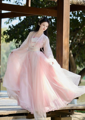 Woman in a flowing Traditional Chinese Clothing - Pink Tang Dynasty Hezi Qun Hanfu Dress standing outdoors with greenery in the background