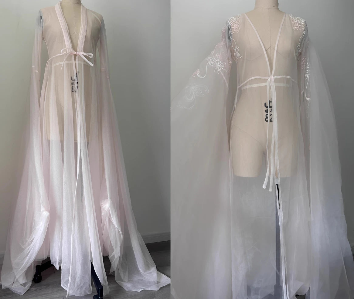 Sheer white lace dress on a mannequin against a plain background