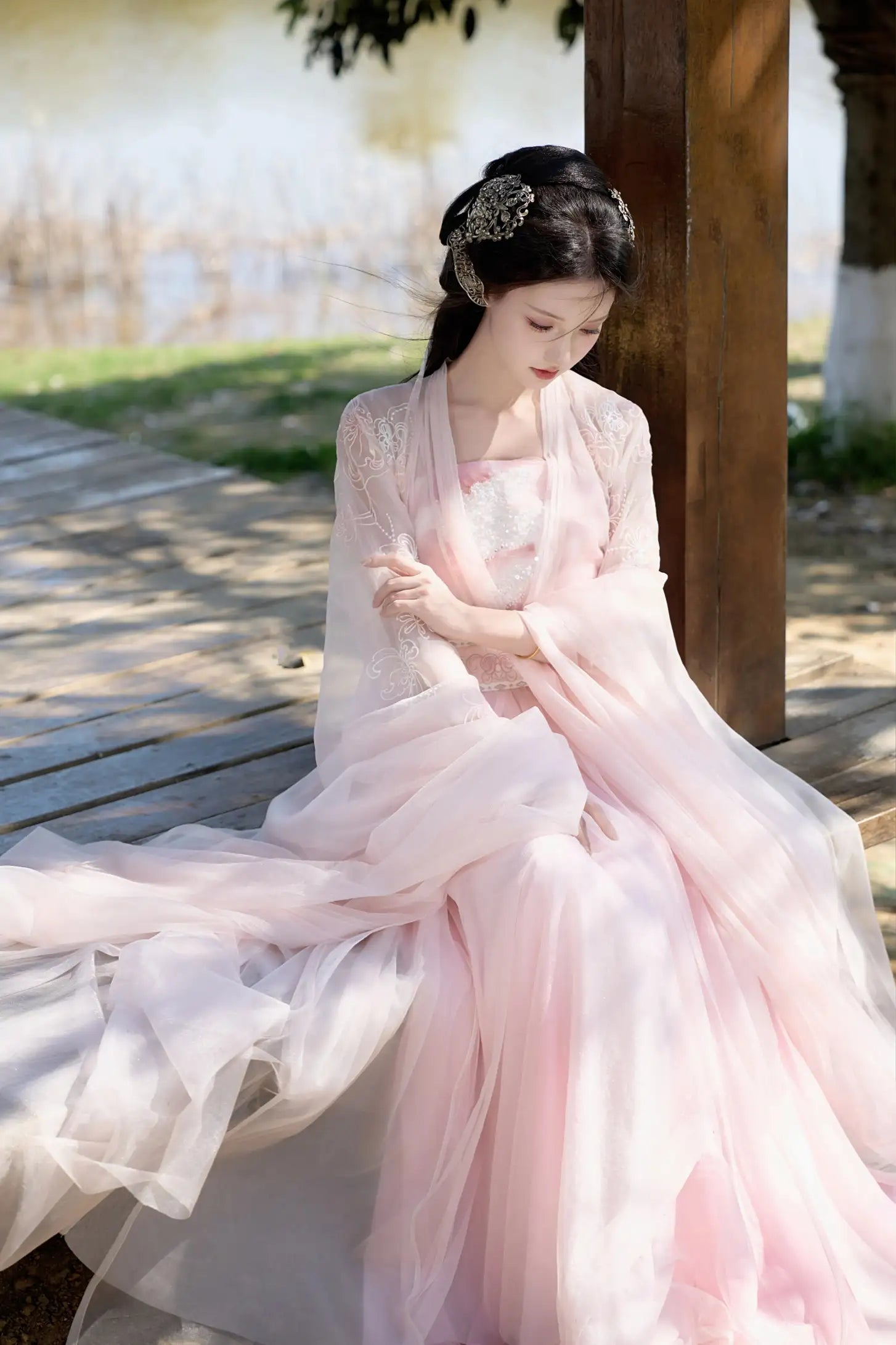 Woman in a Traditional Chinese Clothing - Pink Tang Dynasty Hezi Qun Hanfu Dress  sitting outdoors.