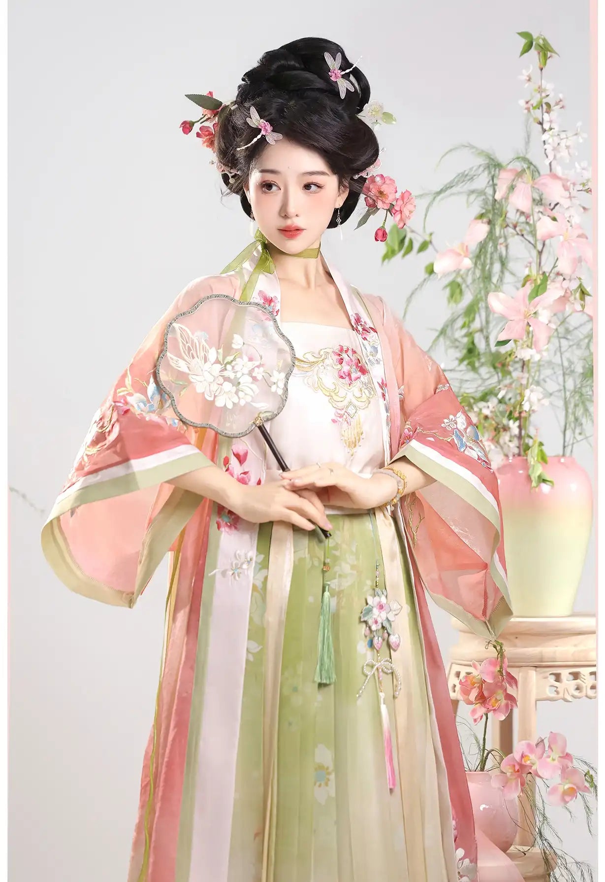 Woman in pink Traditional Chinese Dress – Elegant Song Dynasty Hanfu Set with floral decorations and a fan, standing against a light background.