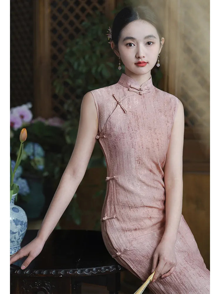 Woman in aTraditional Chinese  Pastel Pink Sleeveless Qipao Dress sitting indoors with a blurred background