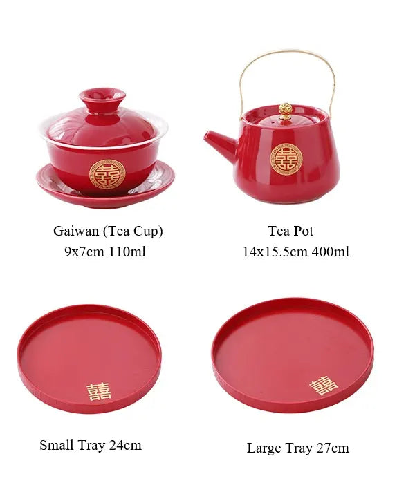 Red ceramic tea set with teapot, teacup, small and large trays on a white background.