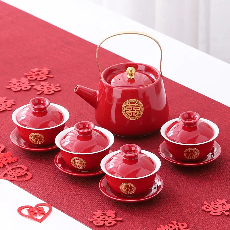 Traditional Chinese Red  Double Happiness Wedding  teapot and cups set on a red tablecloth with festive decorations.