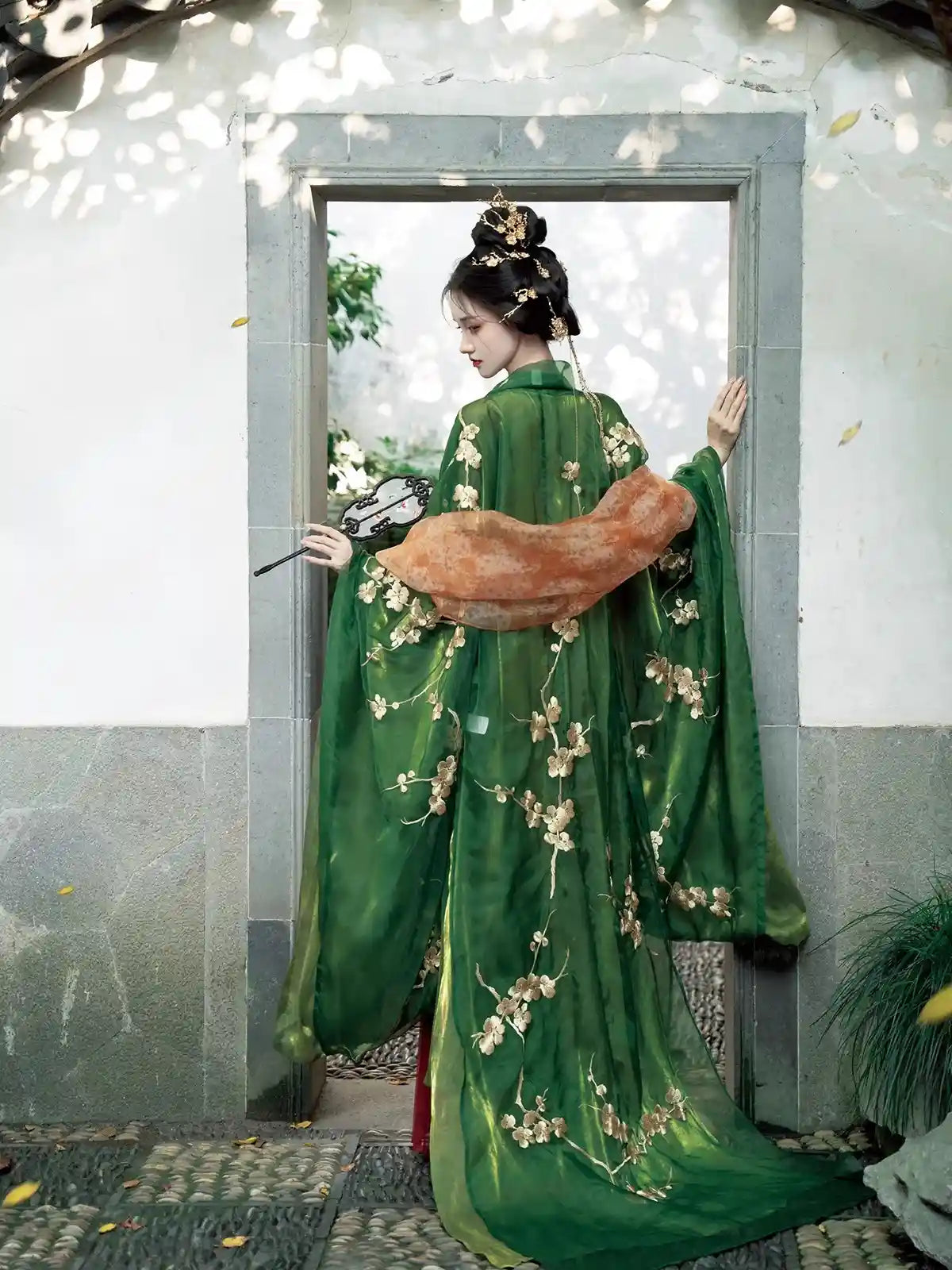 a chinese girl in Traditional Chinese Tang Dynasty Green Hanfu Dress with floral patterns standing in a doorway.