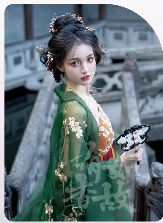 Person in Traditional Chinese Tang Dynasty Green Hanfu Dress  attire with decorative hairpiece and floral design, holding a fan.
