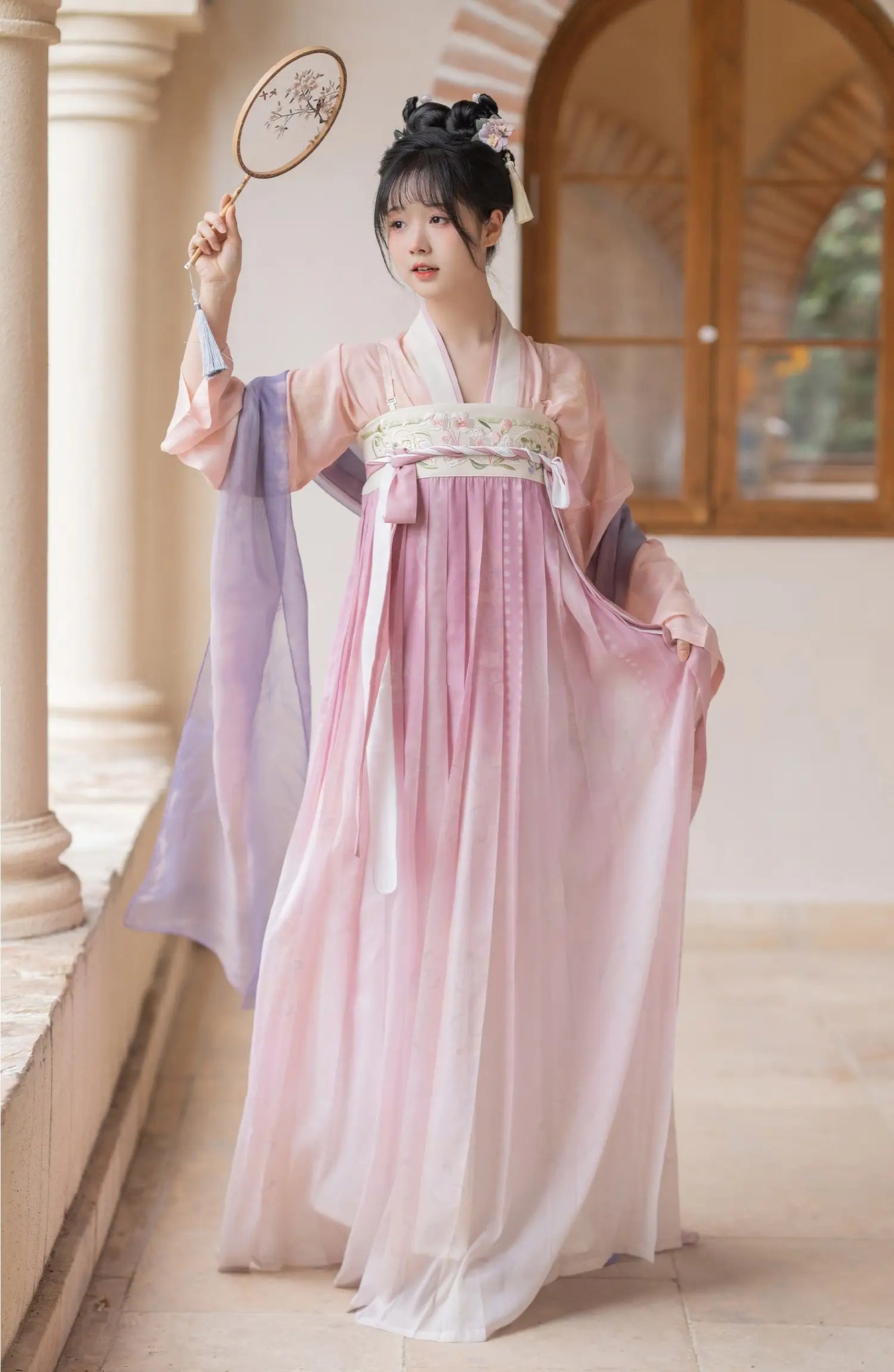 Woman in a Traditional Chinese Tang Dynasty Pink Hanfu Dress Clothing  holding a fan indoors.