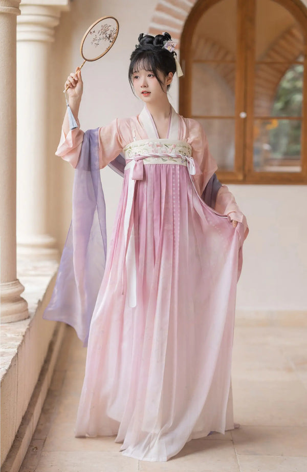 Woman in a Traditional Chinese Tang Dynasty Pink Hanfu Dress Clothing  holding a fan indoors.