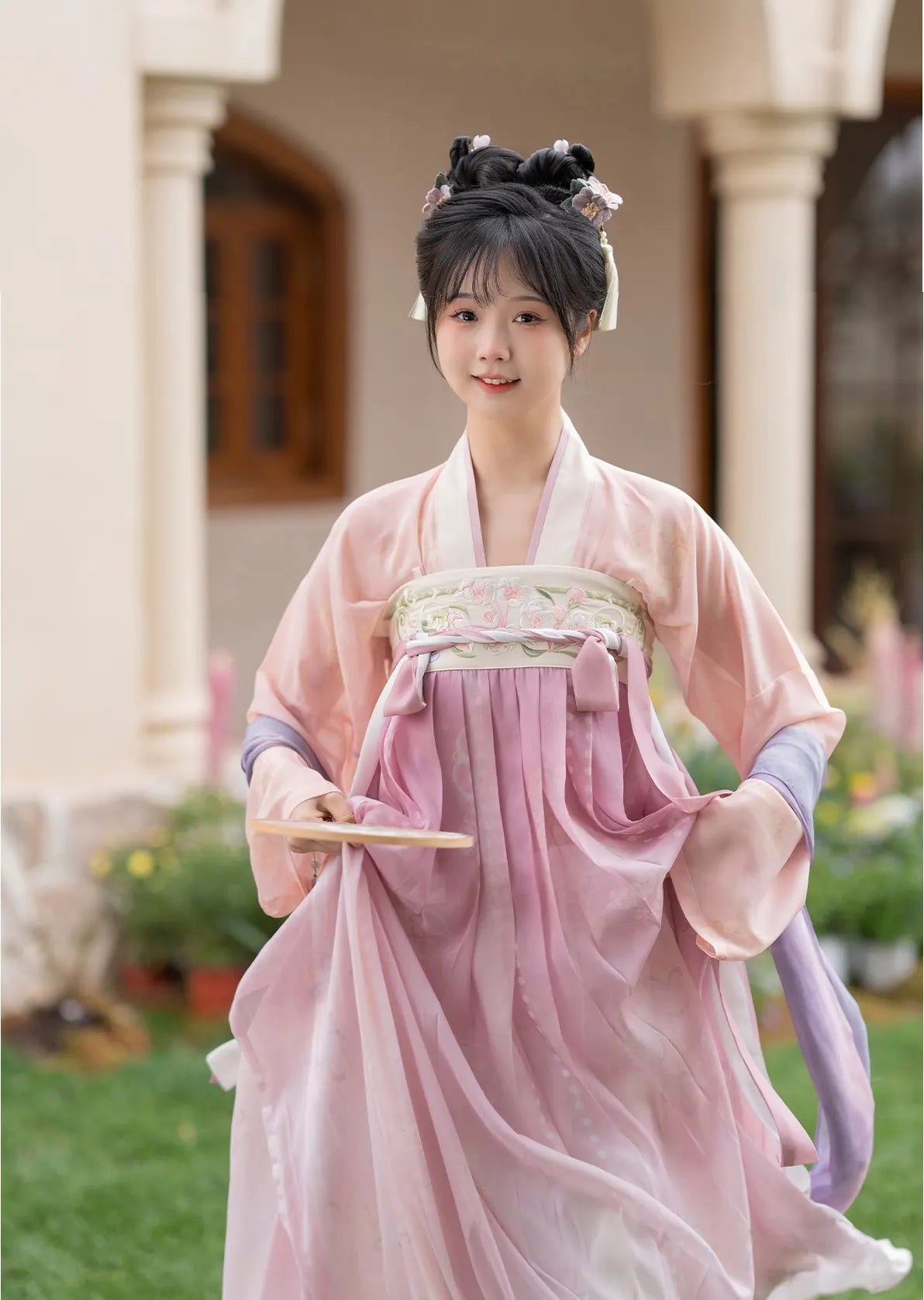 Woman in Traditional Chinese Tang Dynasty Pink Hanfu Dress Clothing   with floral hair accessories outdoors.