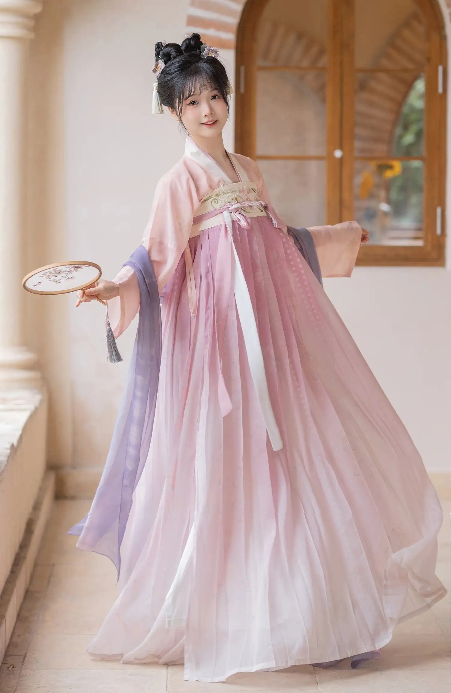 Woman in a Traditional Chinese Tang Dynasty Pink Hanfu Dress Clothing   holding a fan indoors.