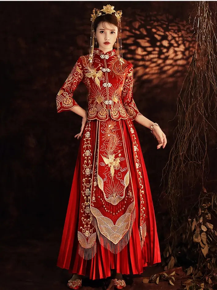 A woman wearing a traditional Chinese red and gold embroidered qun kwa xiuhe wedding dress with a matching headpiece, posed against a dark, atmospheric background with warm light projections.
