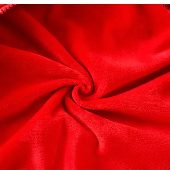 A close-up of bright red fabric with a soft, slightly plush texture, arranged in a spiral drape pattern.