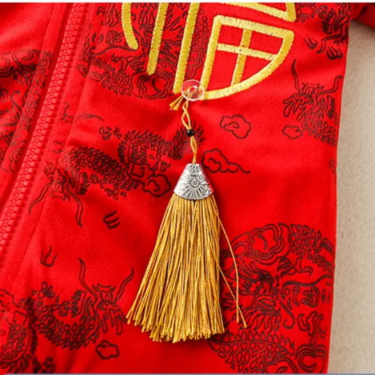 Close-up of a Traditional Red Chinese Dragon Baby Romper with Detachable Tiger Hood with black dragon motifs and a gold tassel charm hanging from a zipper pull.
