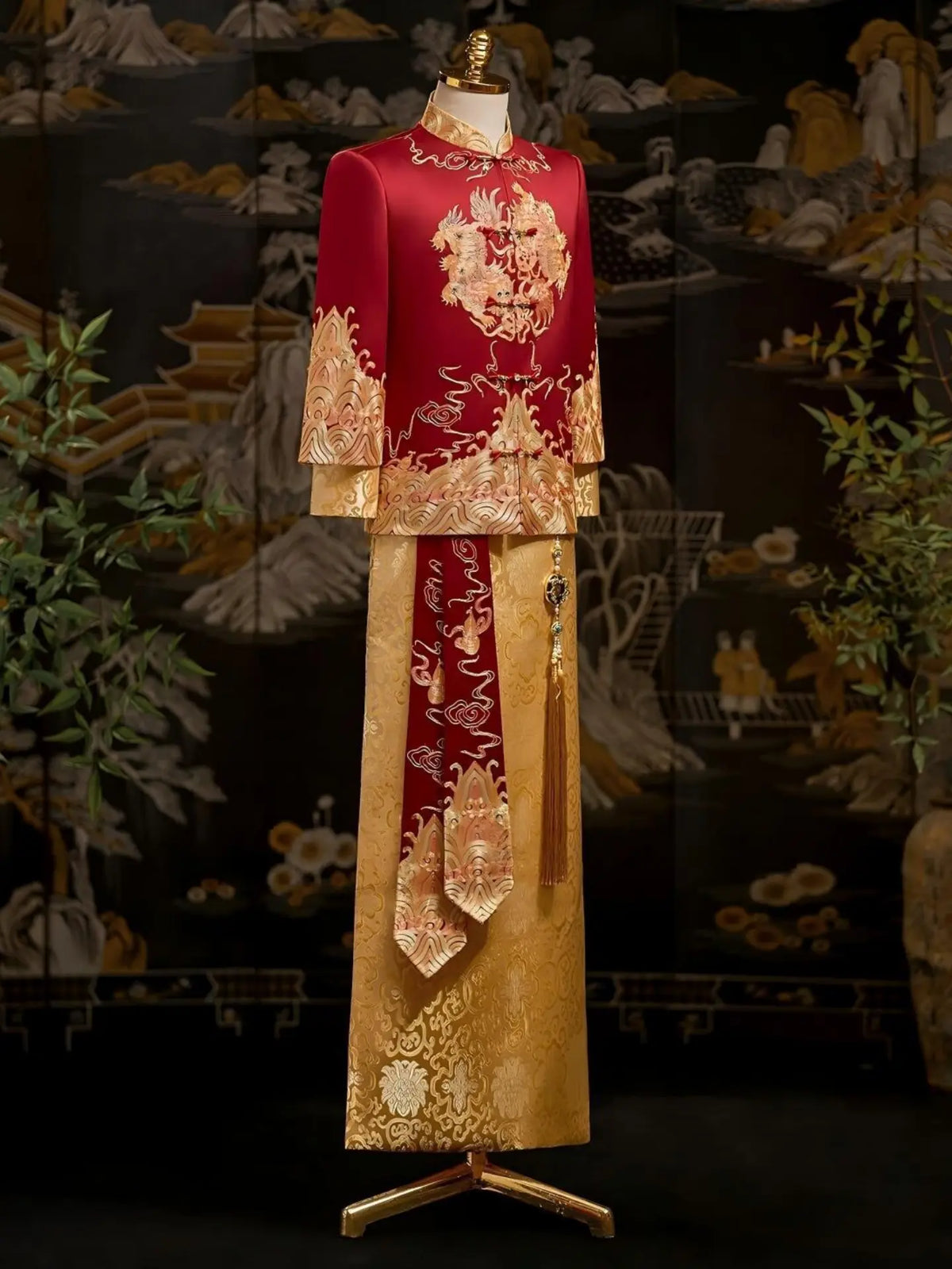 A traditional Chinese groom wedding tang outfit displayed on a mannequin, featuring a red embroidered jacket with gold floral patterns and a matching gold skirt with red embroidered details.