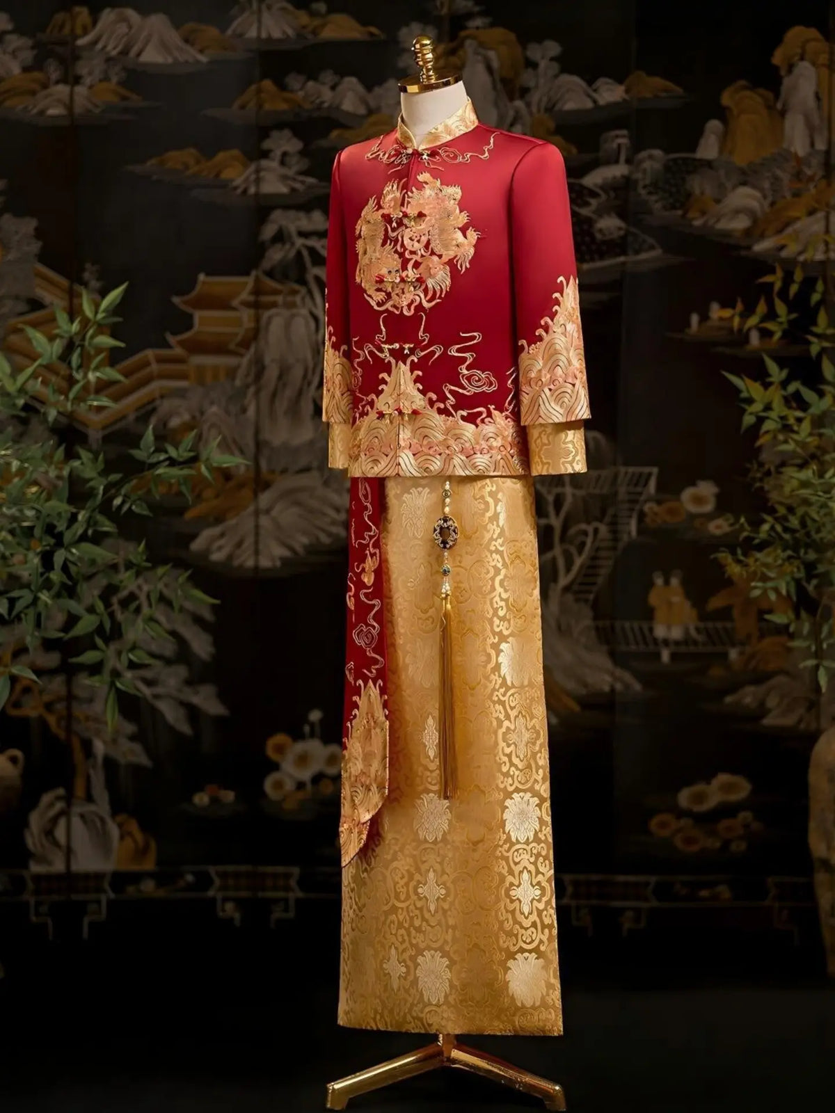 A traditional Chinese groom dragon tang wedding outfit displayed on a mannequin, featuring a red jacket with gold embroidery and a matching gold skirt with floral patterns.