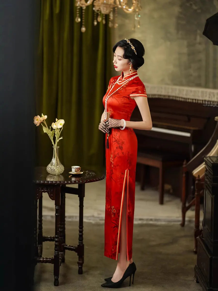 Woman in a Vintage Foral Red Silk Qipao Cheongsam Dress standing in an elegant room with a piano and green curtain.