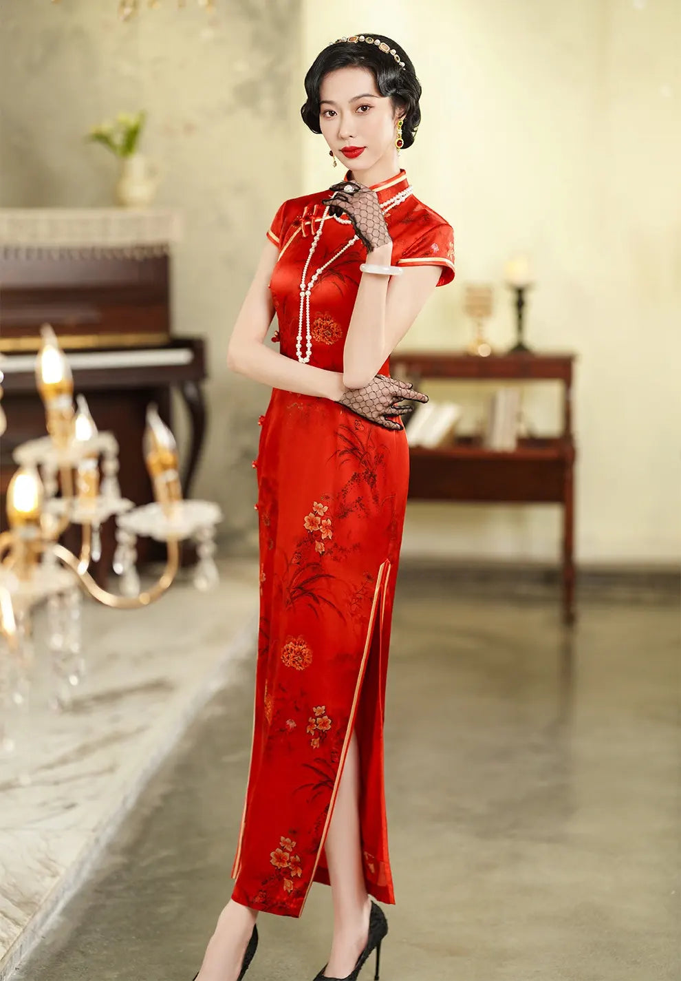 Woman in a Vintage Foral Red Silk Qipao Cheongsam Dress standing in an elegant room with a piano and chandelier.