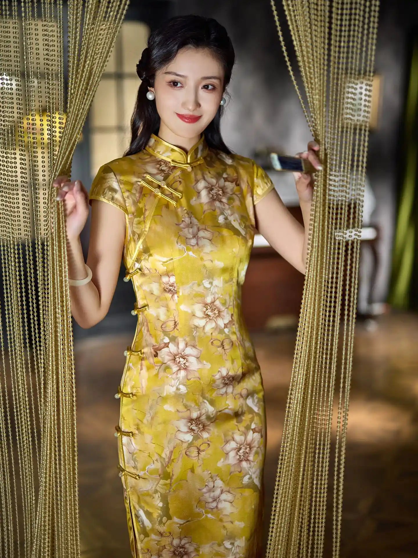 Woman in a yellow floral Vintage Gold Mulberry Silk Chinese Long Qipao Dress dress standing behind gold curtains
