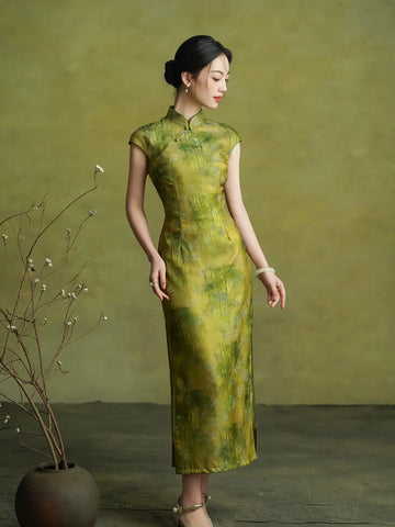 Woman wearing a green dress standing against a plain background