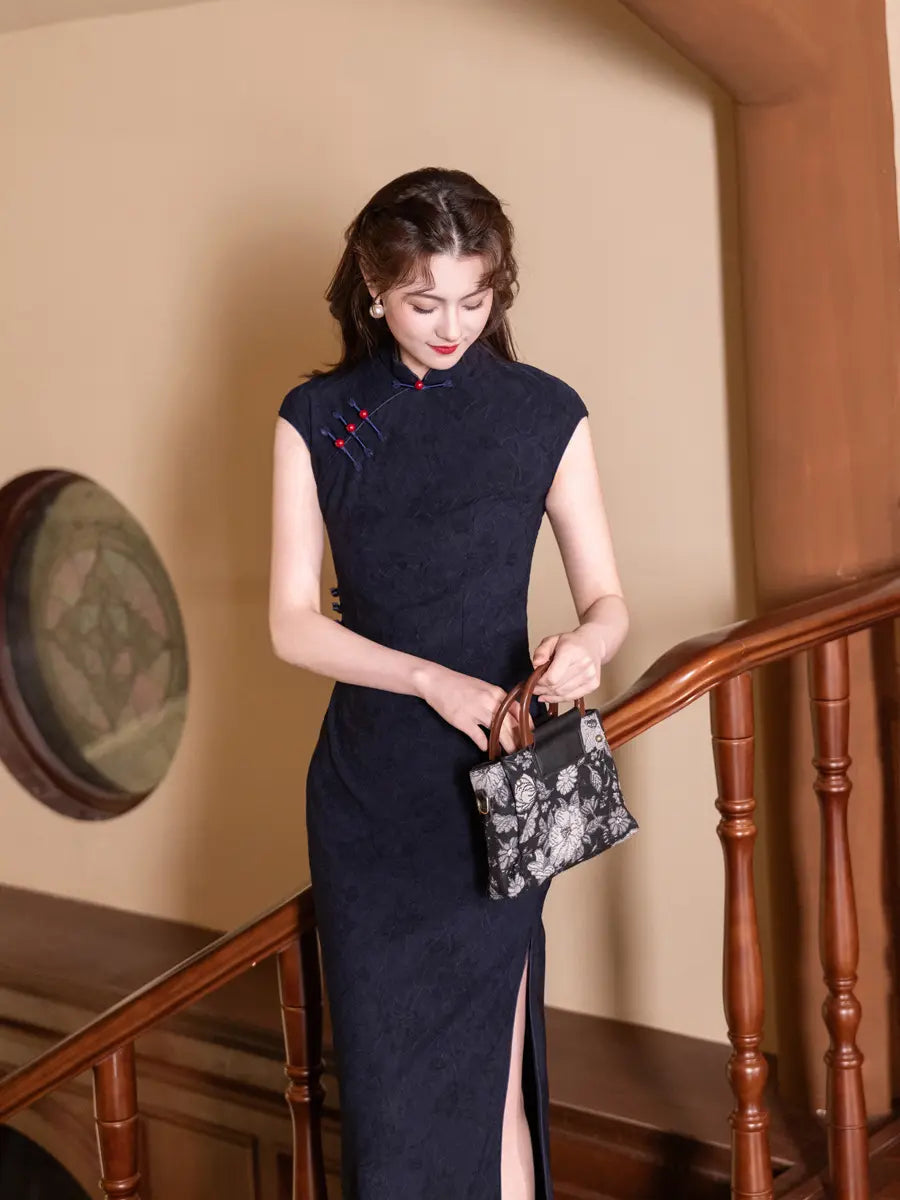 Woman in a darkVintage Navy Blue Jacquard  Sleeveless Qipao Dress With Red Buttons  holding a black handbag indoors.