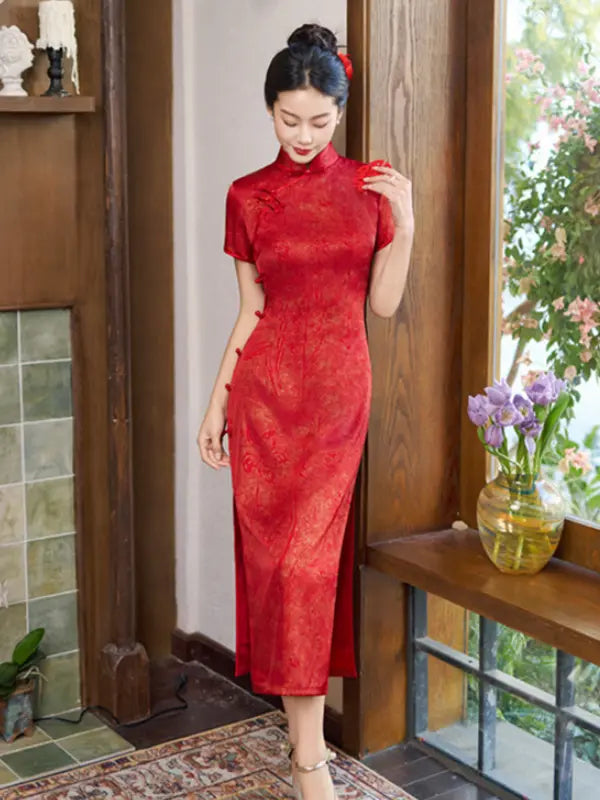 A woman wearing a red short-sleeved cheongsam/qipao dress with a subtle tonal floral pattern, standing in a traditional Chinese-style room with wooden doors and a window.