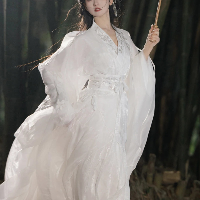 Woman in a  traditional chinese song dynasty hanfu dress holding a wooden staff against a dark background