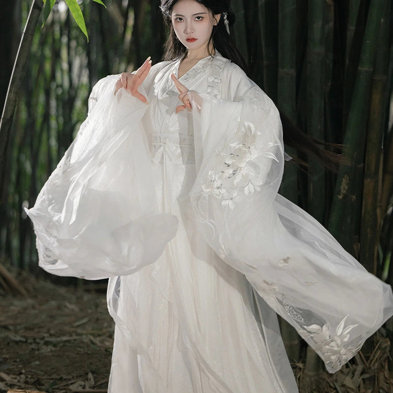 Woman in a White Flowing Song Dynasty Hanfu Dress with floral embroidery standing in a bamboo forest