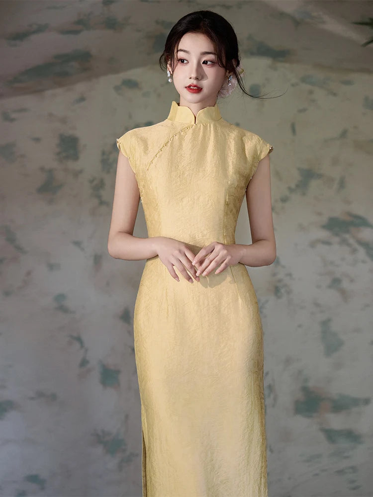 Woman wearing a Yellow Floral Sleeveless Midi Cheongsam Qipao Dress against a textured wall background