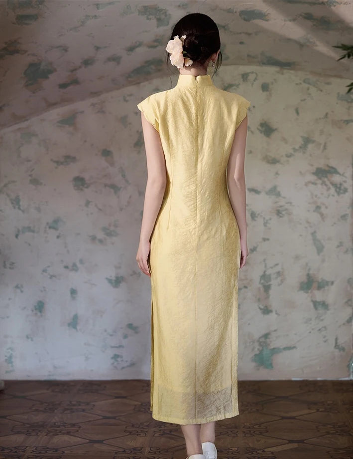 Woman wearing a Yellow Floral Sleeveless Midi Cheongsam Qipao Dress standing in front of a floral wallpapered wall.
