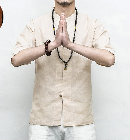 Person wearing a beige Men’s Linen Cotton Chinese Mandarin Collar Shirt  with hands pressed together in a gesture of respect or prayer on a plain background.
