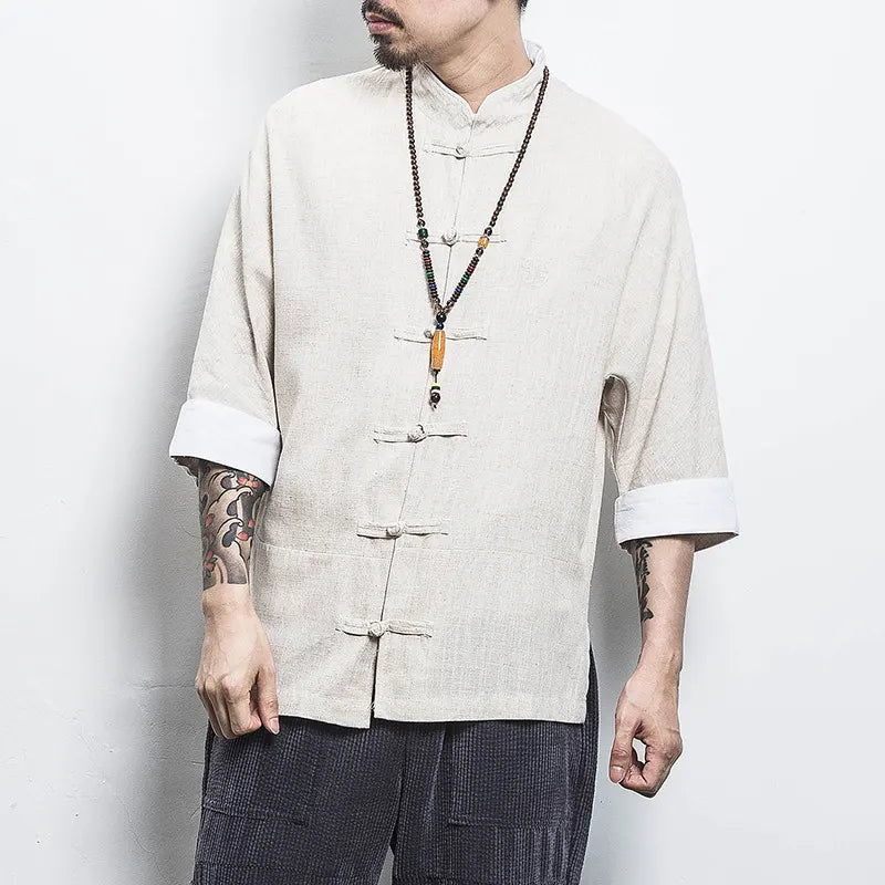 Person wearing a beige traditional  Three-Quarter Sleeve Zen Heritage Linen-Blend Kong Fu Tang Shirt jacket with rolled-up sleeves against a white background
