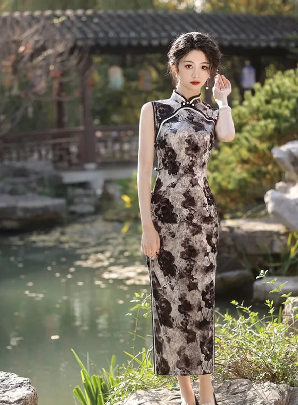Woman in black Floral Sleeveless Velvet Qipao Dress standing in a garden with a pond and wooden structures.