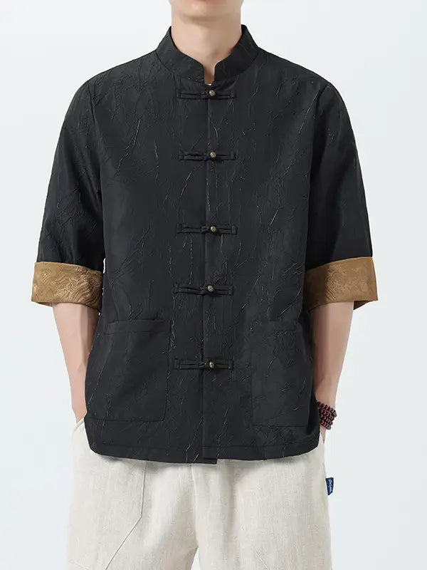 Person wearing a black traditional-style Men's Retro Crinkle Texture Half Sleeve Tang Suit Summer Shirt with brown cuffs on a white background