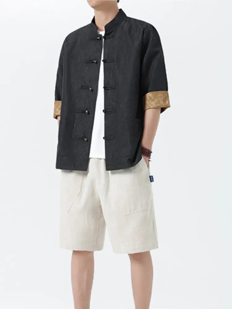 Person wearing a black Men's Retro Crinkle Texture Half Sleeve Tang Suit Summer Shirt  with beige accents and white shorts on a white background
