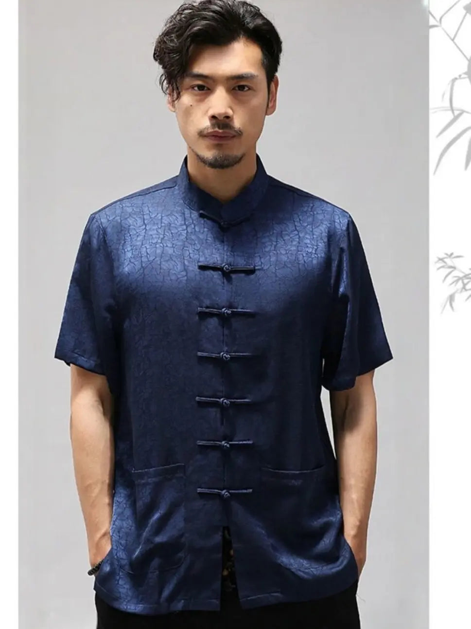 Man wearing a dark blue traditional Men's Luxury Mulberry Silk Jacquard Short Sleeve Tang Shirt  against a plain background