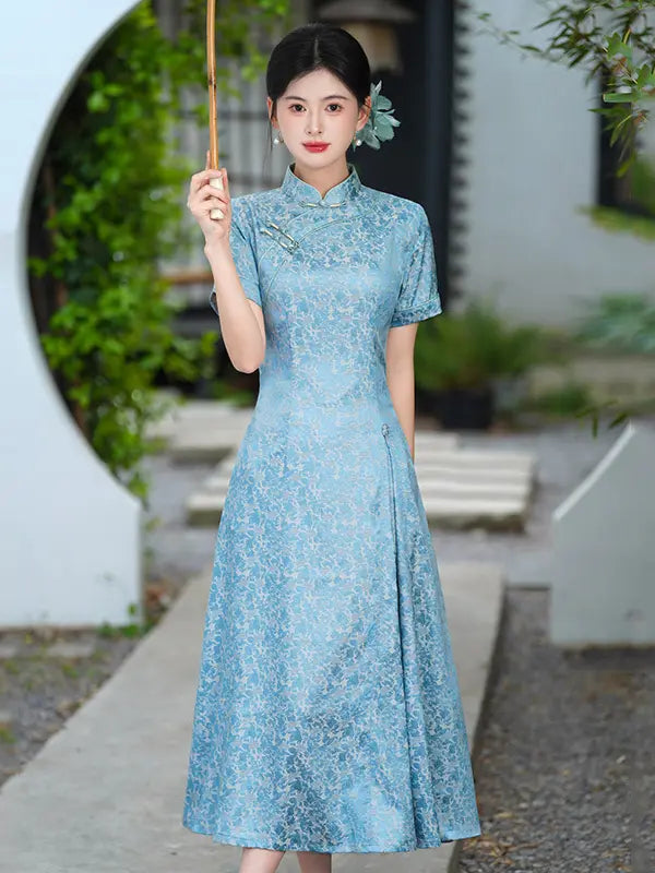 Woman in a blue Modern Floral Short Sleeve A-Line Qipao Dress holding a walking stick outdoors.