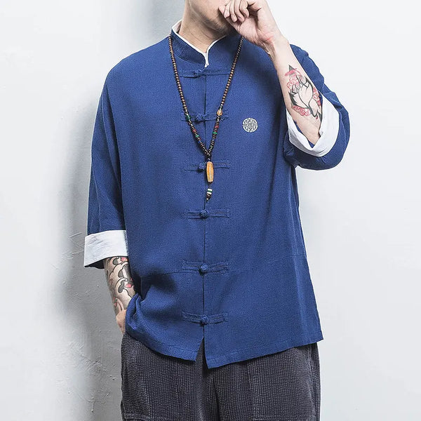 Person wearing a blue traditional  Three-Quarter Sleeve Zen Heritage Linen-Blend Kong Fu Tang Shirt jacket with a white background