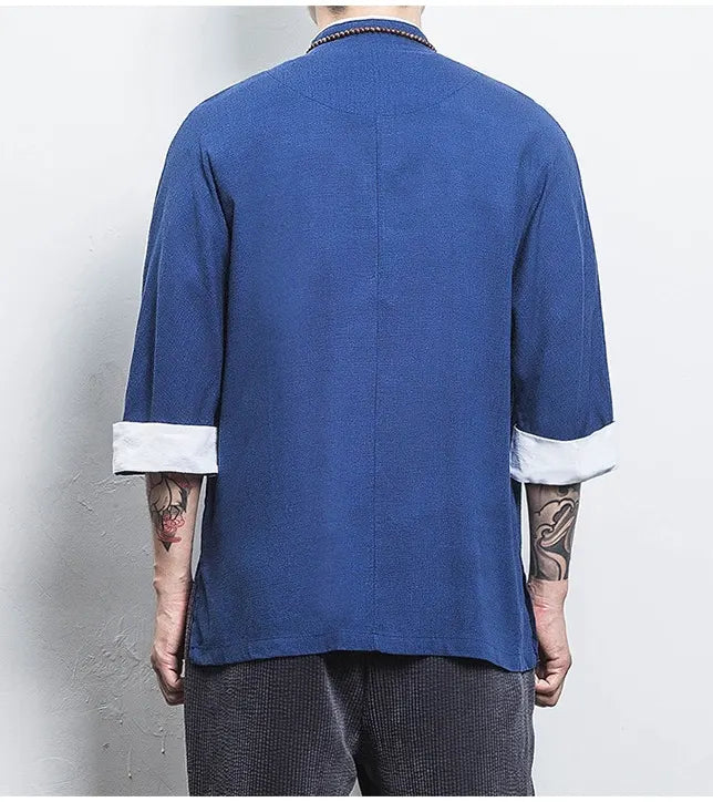 Person wearing a blue Three-Quarter Sleeve Zen Heritage Linen-Blend Kong Fu Tang Shirt  with white cuffs and collar against a plain background