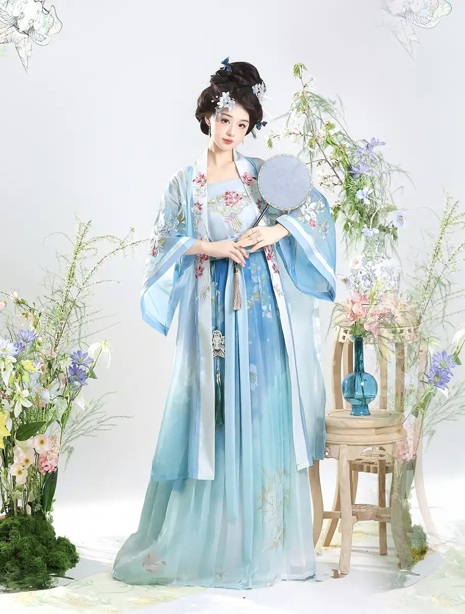 Person in traditional light blue Traditional Chinese Dress – Elegant Song Dynasty Hanfu Set  with floral patterns, standing in a decorated room with flowers and a stool.