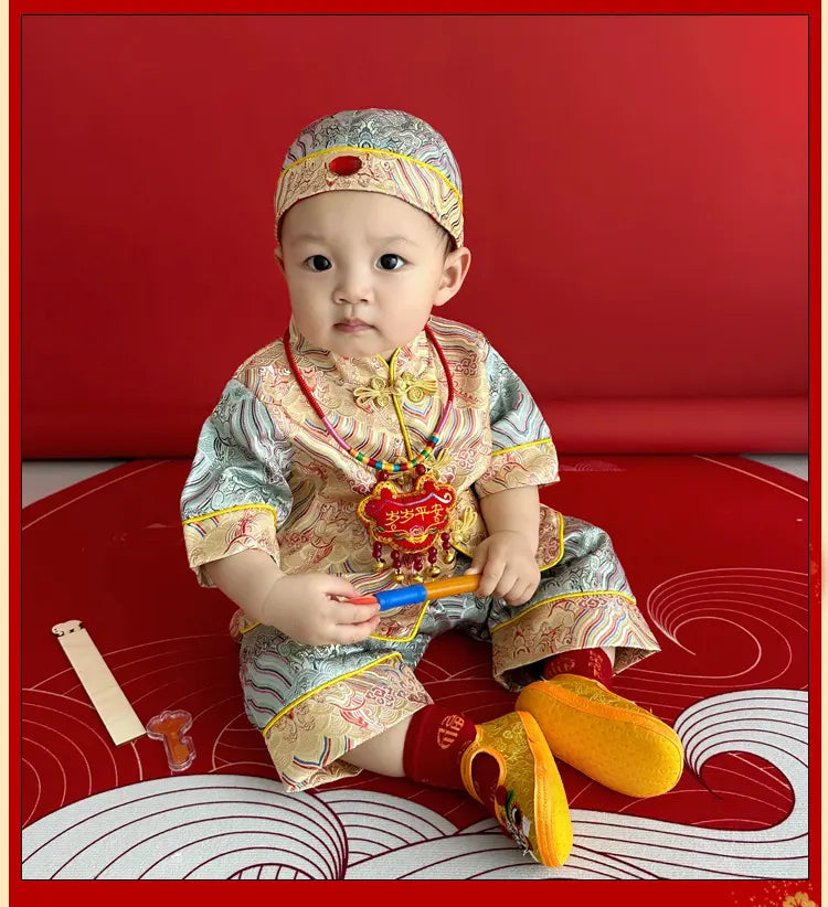 Baby in traditional Blue and Gold Baby Tang Jacket Set outfit with red background