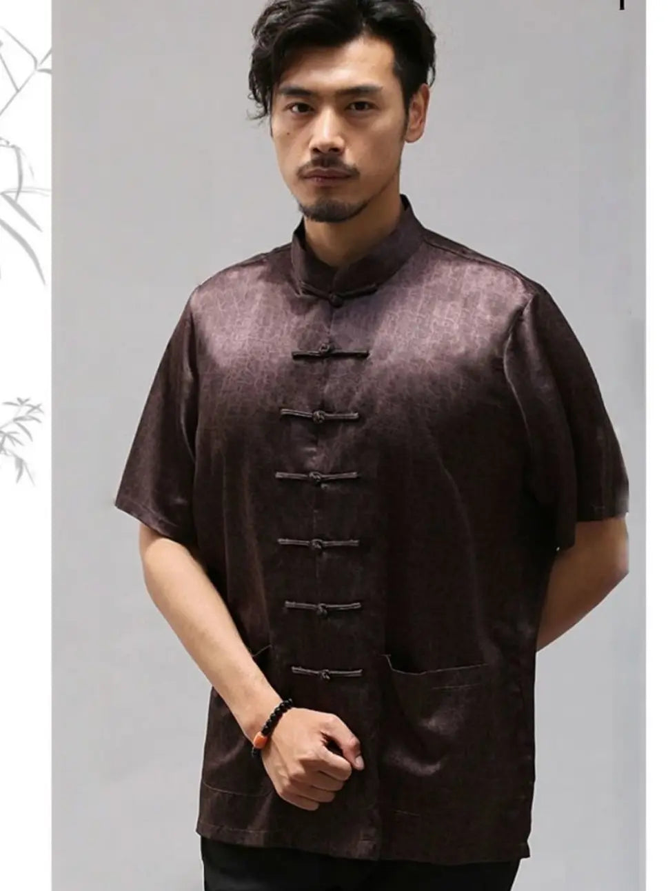 Man wearing a brown traditional Men's Luxury Mulberry Silk Jacquard Short Sleeve Tang Shirt against a gray background