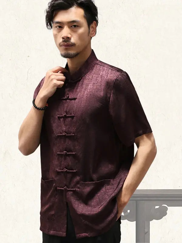 Man wearing a dark burgundy  traditional Men's Luxury Mulberry Silk Jacquard Short Sleeve Tang Shirt  outfit against a neutral background
