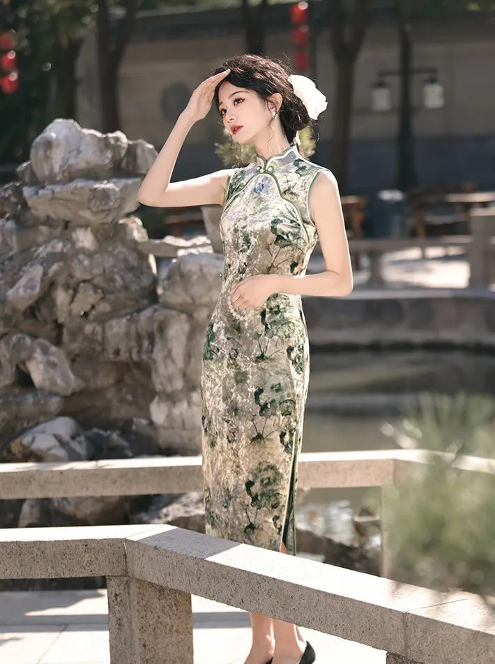 Woman in a traditional green  Floral Sleeveless Velvet cheongsam Dress  standing by a stone wall and water body