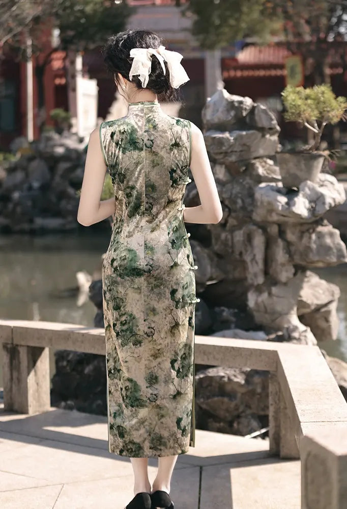 Woman in a green  Floral Sleeveless Velvet chinese Qipao Dress  standing in a scenic outdoor setting with rocks and water.