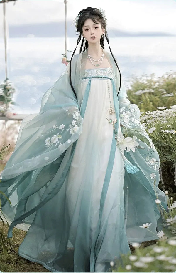 Person in green Floral Traditional Chinese Tang Dynasty Hanfu Dress  with floral details, standing outdoors with a blurred background.
